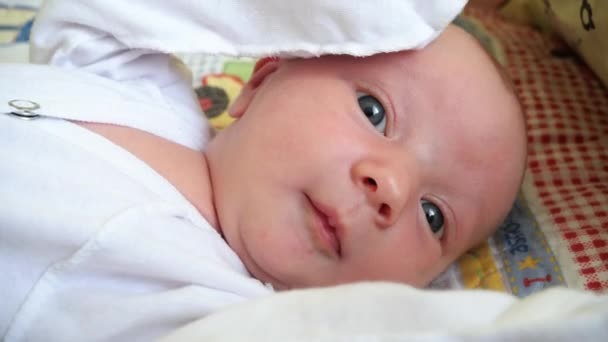 Retrato Primer Plano Bebé Con Ropa Blanca Yace Sobre Espalda — Vídeos de Stock