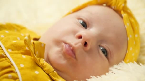Bebê Vestido Bolinhas Amarelas Uma Atadura Amarela Ativamente Gesticulates — Vídeo de Stock