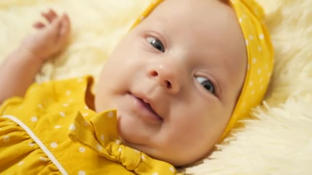 Bebé Con Vestido Amarillo Lunares Una Diadema Amarilla Muestra Lengua — Vídeos de Stock