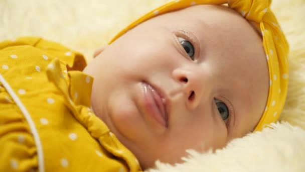 드레스를 아기와 머리에 붕대를 아기가 웃으며 보여준다 클로즈업 — 비디오
