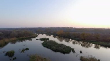 Nehrin üzerinde sonbahar günbatımı. Kamera geri gidiyor..