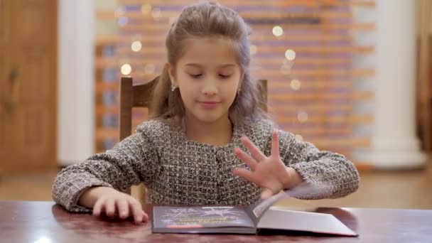 Het Schoolmeisje Opent Het Boek Onderzoekt Enthousiast Illustraties — Stockvideo