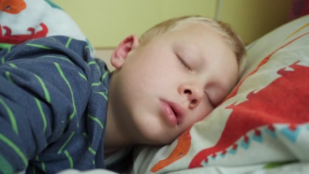 Το αγόρι στριφογυρίζει στον ύπνο της, κοιμάται με το στόμα του ανοιχτό, η μύτη του παιδιού δεν αναπνέει, ως συνέπεια του κρύου. — Αρχείο Βίντεο