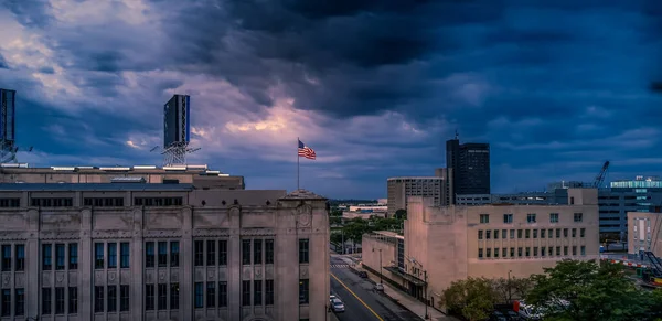 Bandera americana capturada brillantemente en la parte superior de un paisaje de la ciudad antes de una gran tormenta — Foto de Stock