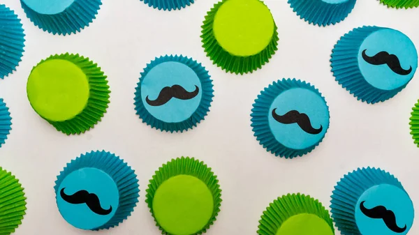 Blue and green mustache cupcake papers themed for a birthday par Stock Photo