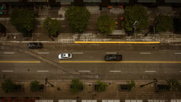 Vista aérea de arriba hacia abajo de los vehículos que conducen por una calle de la ciudad — Foto de Stock