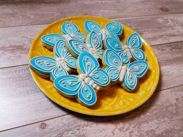 Biscuits abstraits au papillon sur une assiette et un fond jaunes — Photo