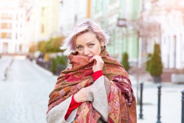 Şehrin arka planında fularlı genç bir kadının portresi..