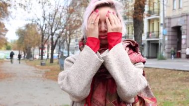 Genç bir kadının portresi. Elleriyle gözlerini kapatıyor ve kameraya bakarken gülümsüyor. Ne hoş bir sürpriz. Yaşam tarzı ve pozitif. Yavaş çekim görüntüleri