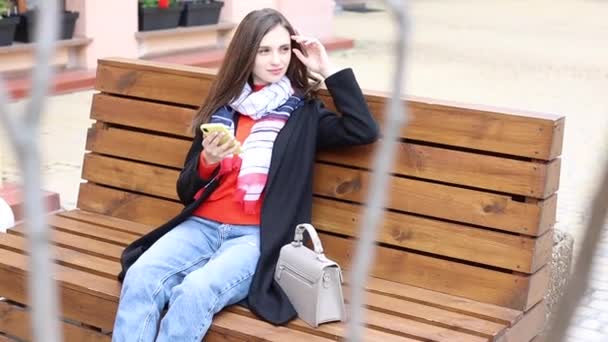 快乐的女人用手挥手 长发黑发的成年女人穿着西服坐在长椅上 与朋友在街上挥手打招呼 慢动作 — 图库视频影像