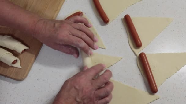 Hands Granny Wrapping Sausages Raw Puff Pastry Grandmother Preparing Hot — Stock Video
