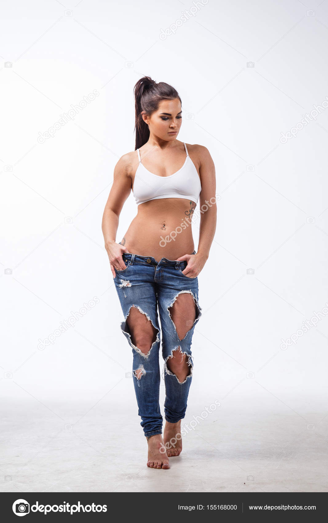 Beautiful blonde girl sexy fitness posing on white background in jeans —  Photo