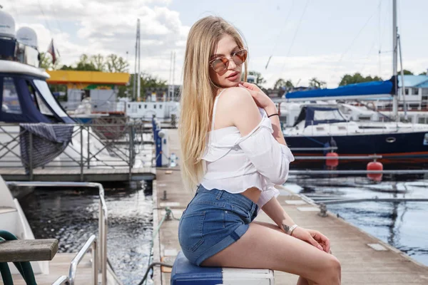 Mooie jonge vrouw die zich voordeed op pier — Stockfoto