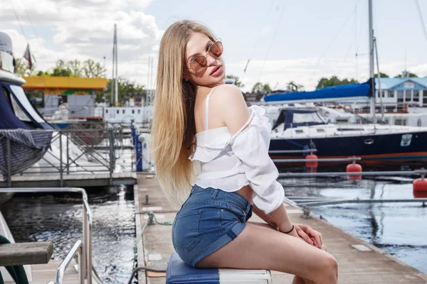 Beautiful young woman posing on pier — Stock Photo, Image