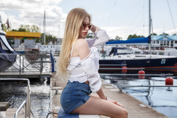 Schöne junge Frau posiert auf Pier — Stockfoto