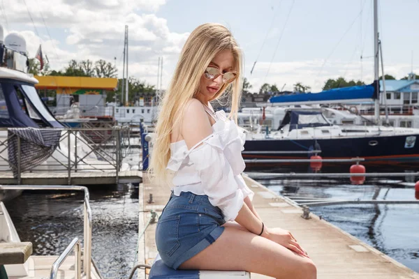 Mooie jonge vrouw die zich voordeed op pier — Stockfoto