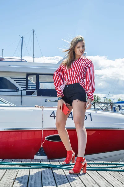 young woman posing near yacht