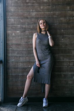 Ahşap duvar önünde gri elbise modeli