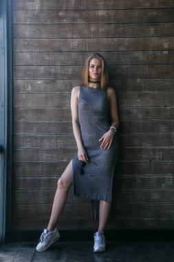 Ahşap duvar önünde gri elbise modeli