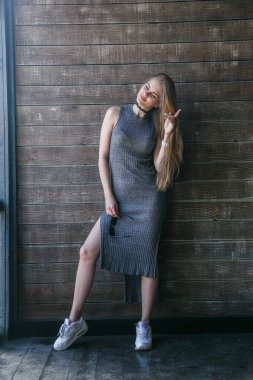 Ahşap duvar önünde gri elbise modeli