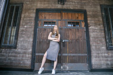 Ahşap binanın önünde gri elbise modeli