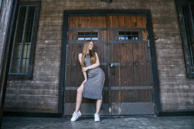 Ahşap binanın önünde gri elbise modeli