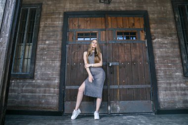 Ahşap binanın önünde gri elbise modeli