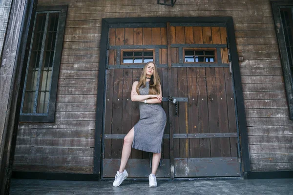 Modelo em vestido cinza na frente do edifício de madeira — Fotografia de Stock