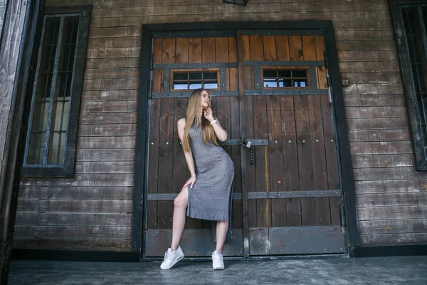 Modelo em vestido cinza na frente do edifício de madeira — Fotografia de Stock