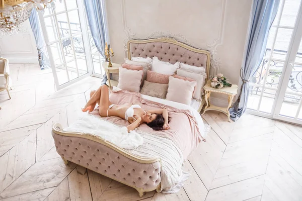 Vrouw die zich voordeed op bed — Stockfoto