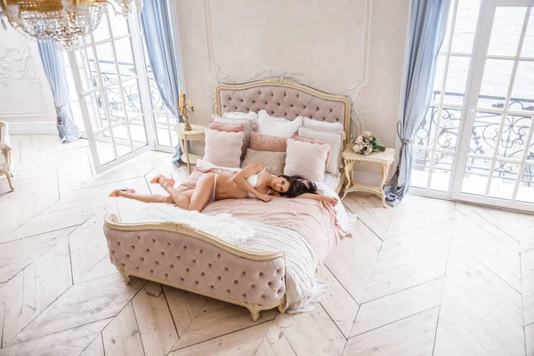 Nő pózol a ágy — Stock Fotó