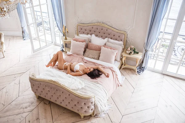 Vrouw die zich voordeed op bed — Stockfoto