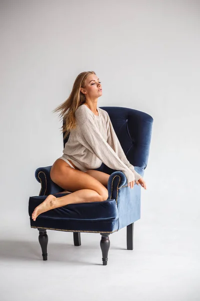 Sexig kvinna som sitter på den blå fåtöljen — Stockfoto