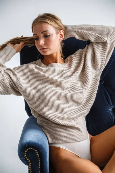 Sexy vrouw zittend op de blauwe leunstoel — Stockfoto