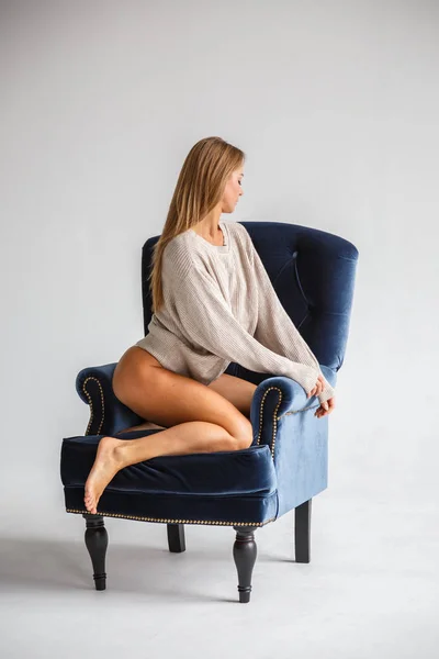 Mujer sexy sentada en el sillón azul — Foto de Stock