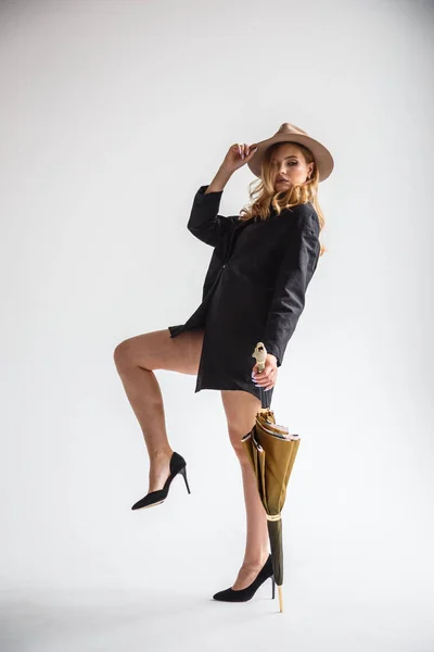 Model dalam kemeja hitam dan topi dengan payung — Stok Foto