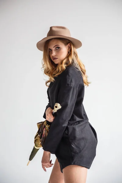 Модель в черной рубашке и шляпе с зонтиком — стоковое фото