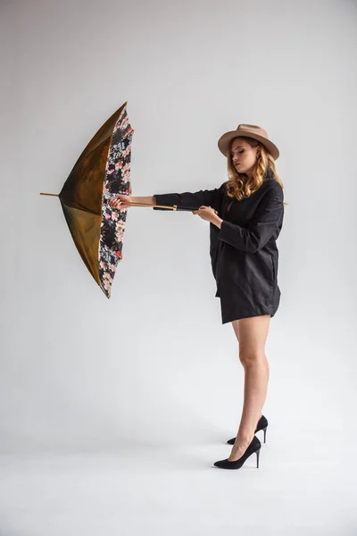 Modèle en chemise noire et chapeau avec parapluie — Photo