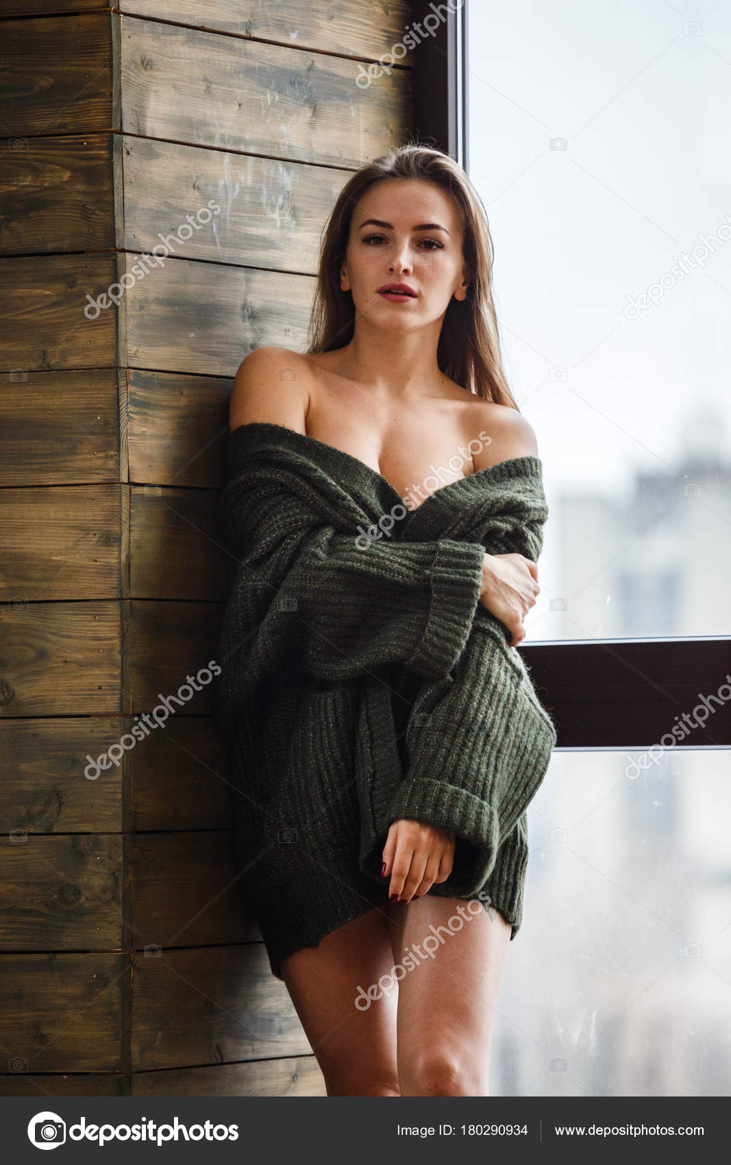 Foto Stock Portrait sexy woman. Attractive beautiful sexy girl is looking  through window, curtain for seeing nice sky. Charming beautiful woman wear  vest because it's hot weather in summer season. She look