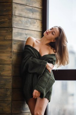 Güzel sarışın seksi iç çamaşırı ve ev iç pencerede bekliyor ceket