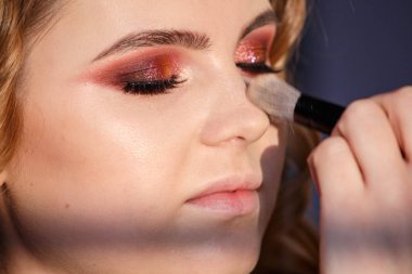 Portre stüdyo portre güzellik genç kadının yüzünde makyaj uygulamak