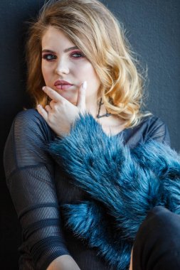 Stüdyo çekim güzellik model siyah bluz ve mavi ceket giyiyor. Şık makyaj, ev iç pencere üzerinde oturan genç kadınla