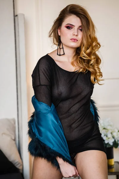 黒のブラウスと青のコートを着て美モデルのスタジオ撮影 スタイリッシュな化粧自宅ポーズを持つ若い女性 — ストック写真