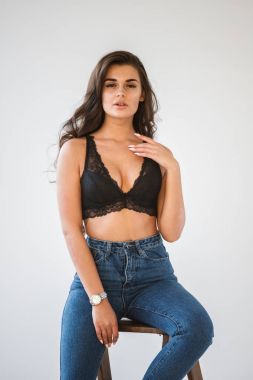 Mavi jeans ve Ahşap merdiven, beyaz duvar arka plan eğilerek cinsel siyah iç çamaşırı giyen güzel kıvırcık esmer kız portresi stüdyo