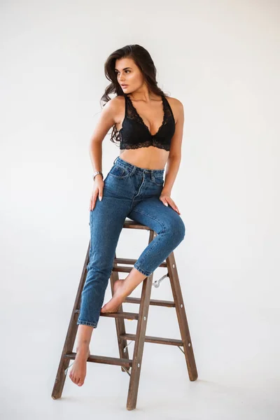 Mavi Jeans Ahşap Merdiven Beyaz Duvar Arka Plan Eğilerek Cinsel — Stok fotoğraf