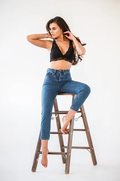 Retrato Estudio Una Hermosa Chica Morena Rizada Con Vaqueros Azules —  Fotos de Stock