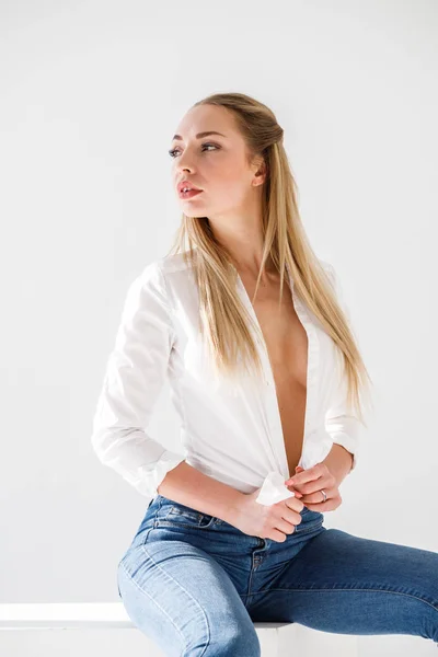 Portrét Sexy Blond Dívka Sobě Modré Džíny Bílou Košili Sedí — Stock fotografie