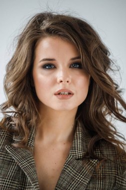 Giyen güzel kıvırcık kadın portre stüdyo portre rahat takım elbise, beyaz duvar arka plan üzerinde duran kareli 