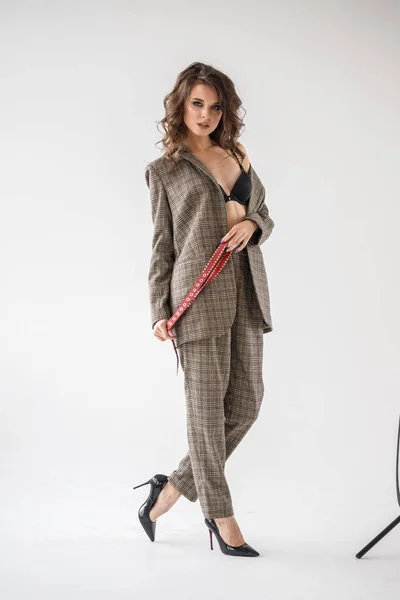 캐주얼 양복과 벨트와 배경에 브래지어를 여자의 스튜디오 초상화 — 스톡 사진
