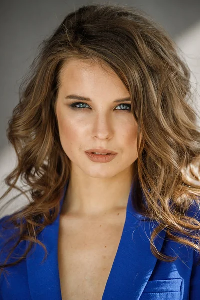 Portre stüdyo portre güzel kıvırcık kadın giyiyor mavi ceket, gri duvar arka plan